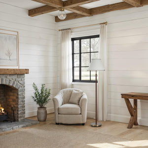 Elea floor lamp in a cozy living room with a stone fireplace and a beige armchair.