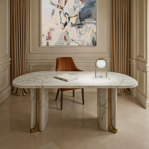 Barca table lamp on a marble desk in an elegant office with a painting and a chair.