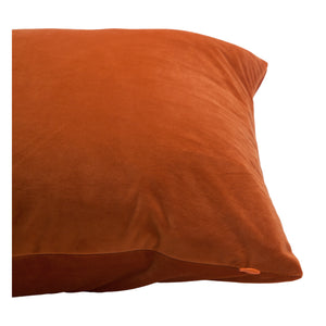 Prato Indoor Pillow in rich orange velvet, angled view showing soft texture and subtle seam detail.