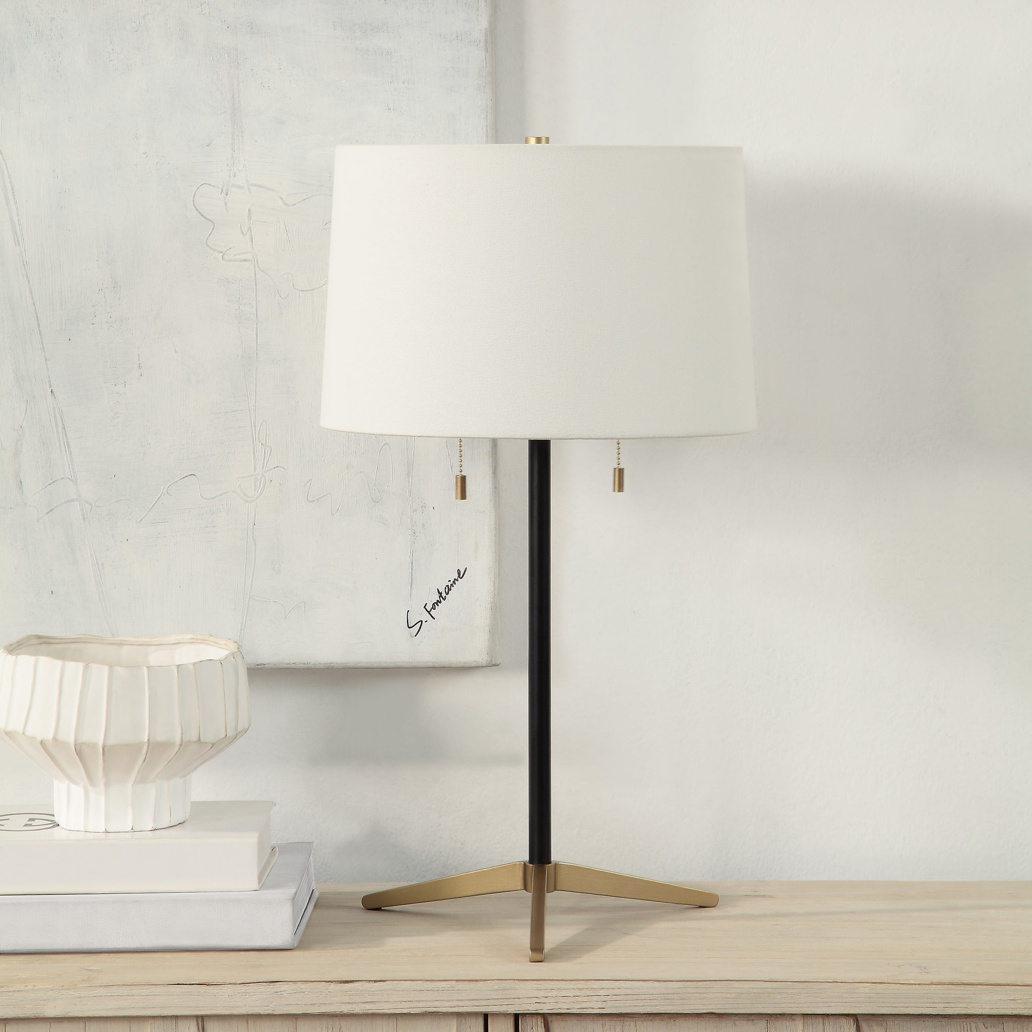 Orono Table Lamp styled on a table with a white shade and gold details