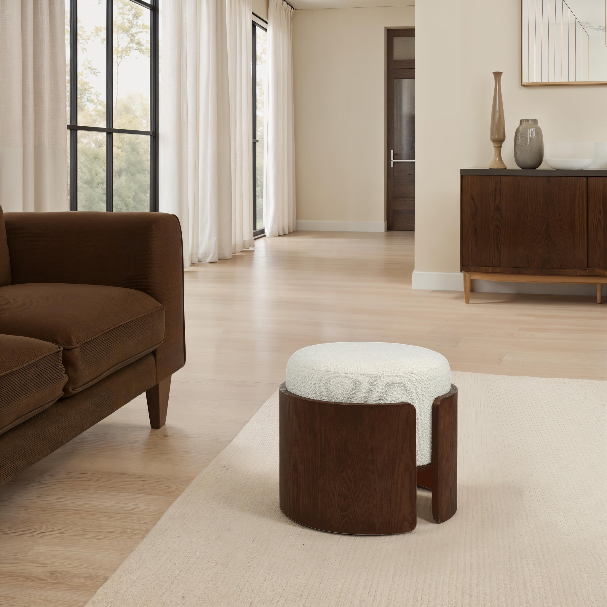 Capsula Ottoman in a modern living room setting beside a brown sofa
