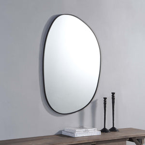 Bozeman Wall Mirror mounted on a gray wall above a wooden table.