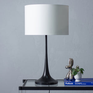 Salvora Table Lamp featuring a sleek black base and a white shade, placed on a glass table.