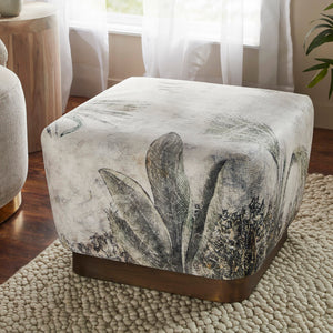 Tangle Ottoman in a living room setting, highlighting its floral fabric and wooden base.