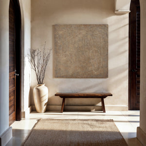 Berkeley canvas art featuring abstract beige design, displayed in a sunlit entryway with wooden bench and vase.
