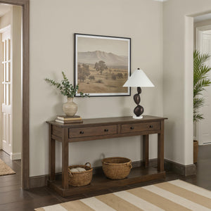Elle table lamp on a wooden console table in a room with artwork and greenery.