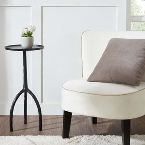 Konsta Table beside a white chair with a cushion and a potted plant