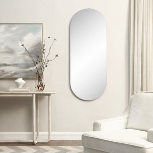 Kastelli mirror mounted on a wall beside a decorative table and artwork.