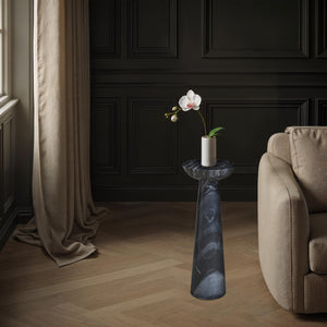 Mercura side table styled in a living room with a flower vase, next to a beige sofa.
