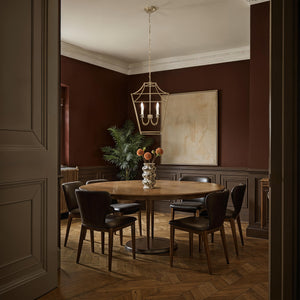 Versailles pendant light hanging over a round wooden dining table in a stylish dining room.