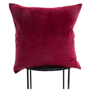 Cora Indoor Pillow in deep red velvet, displayed on a black metal stand.