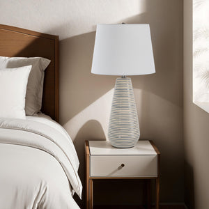 Pera Table Lamp on a nightstand beside a bed in a softly lit bedroom