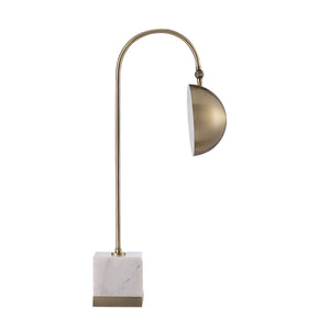 Volos Table Lamp featuring a curved brass arm and a dome shade, resting on a white marble base.