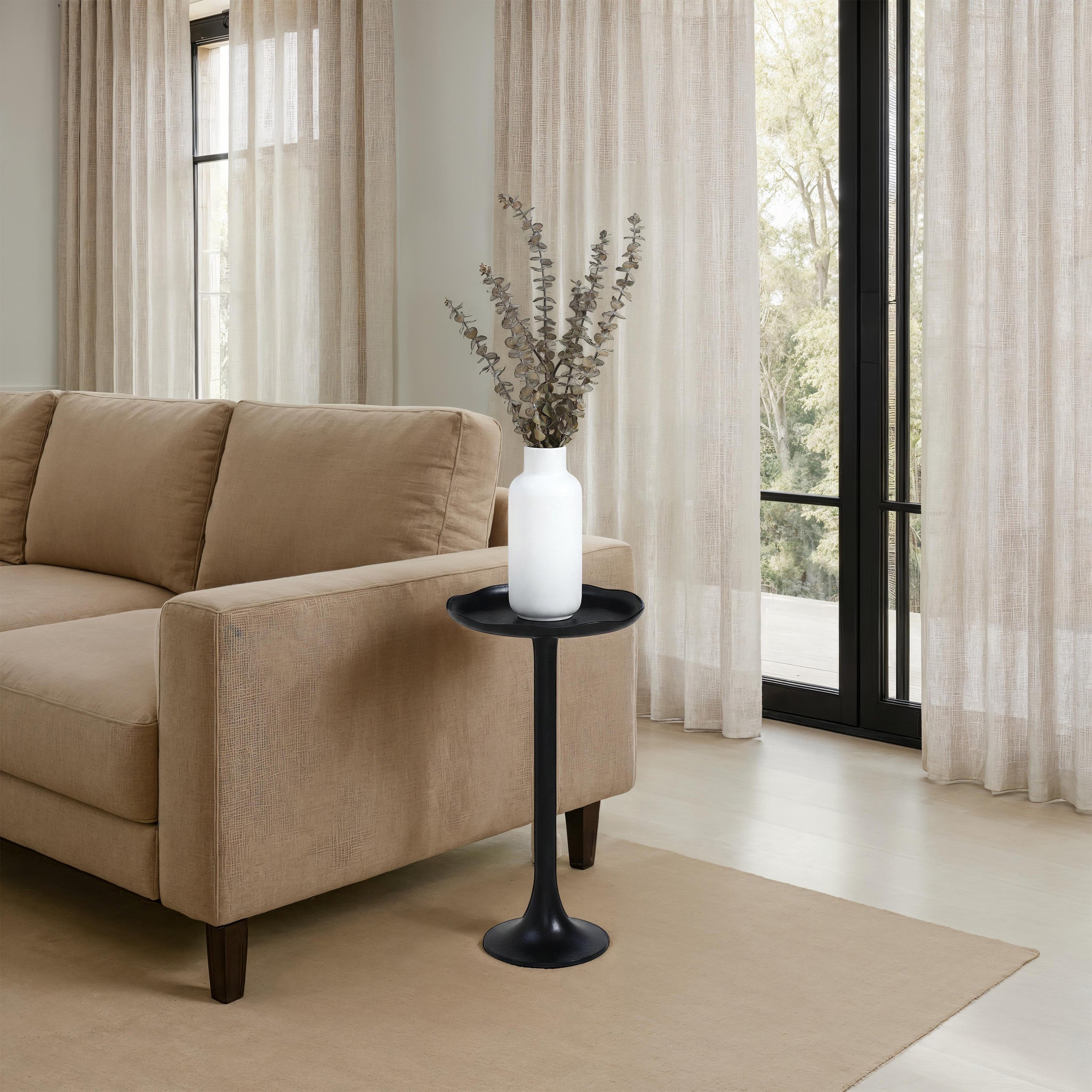 Fiora side table beside a beige sofa, adorned with a white vase and greenery.