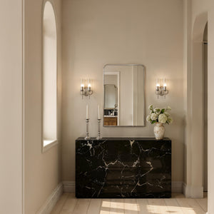 Jackline mirror by Renwil displayed in a stylish interior, above a black marble console with candles and flowers.