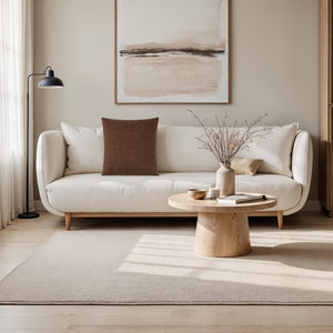 Ferro pillow in brown on a modern white sofa with a minimalist decor.