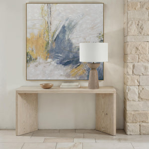 Alba Table Lamp placed on a light wood table, accompanied by a decorative bowl and abstract art.