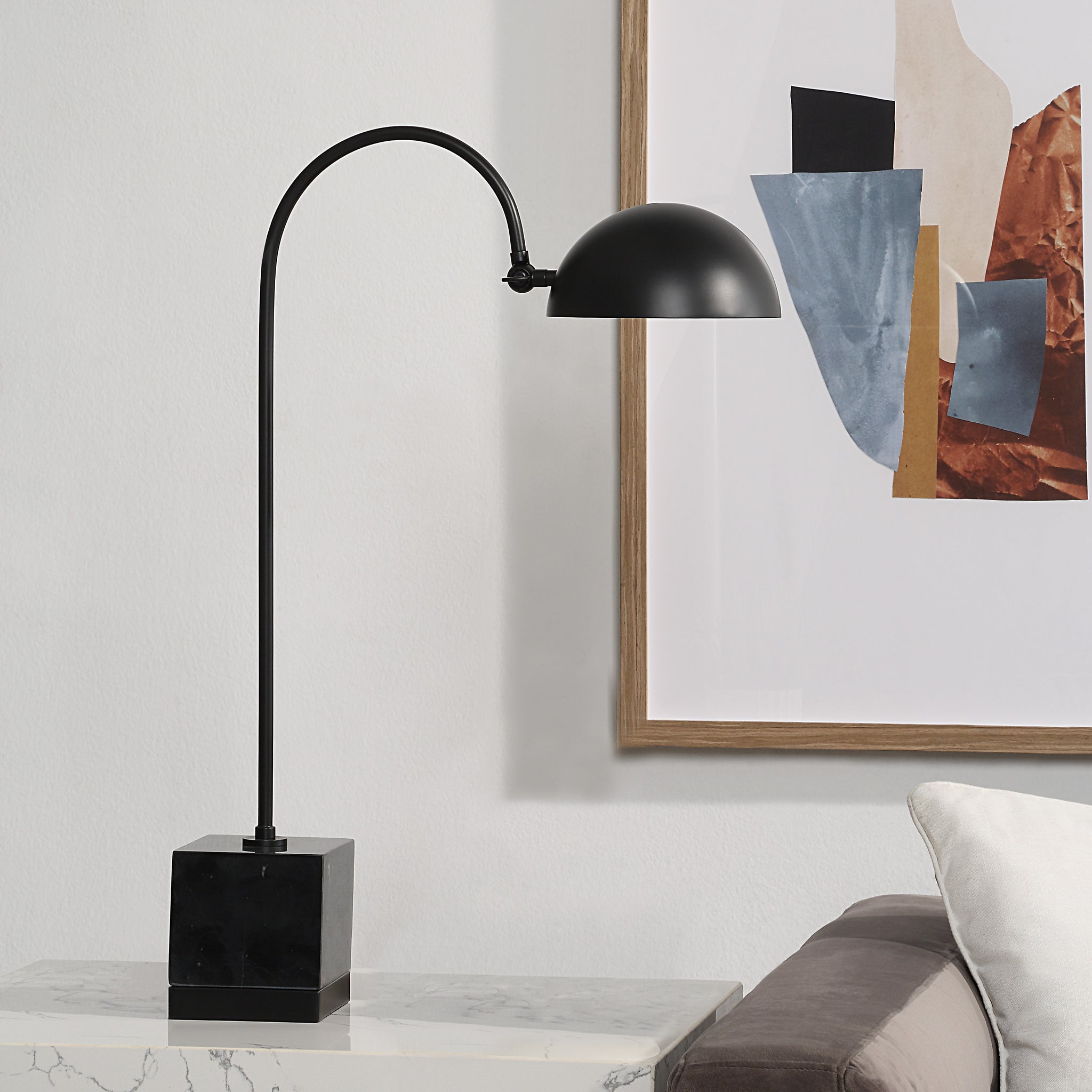 Sansia Table Lamp positioned beside a couch and artwork, showcasing its design.