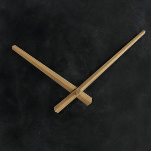 Close-up of Darnay Wall Clock's gold hands against a black background.
