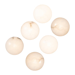Haloa wall sconce displaying six light-colored alabaster spheres with subtle marbling.